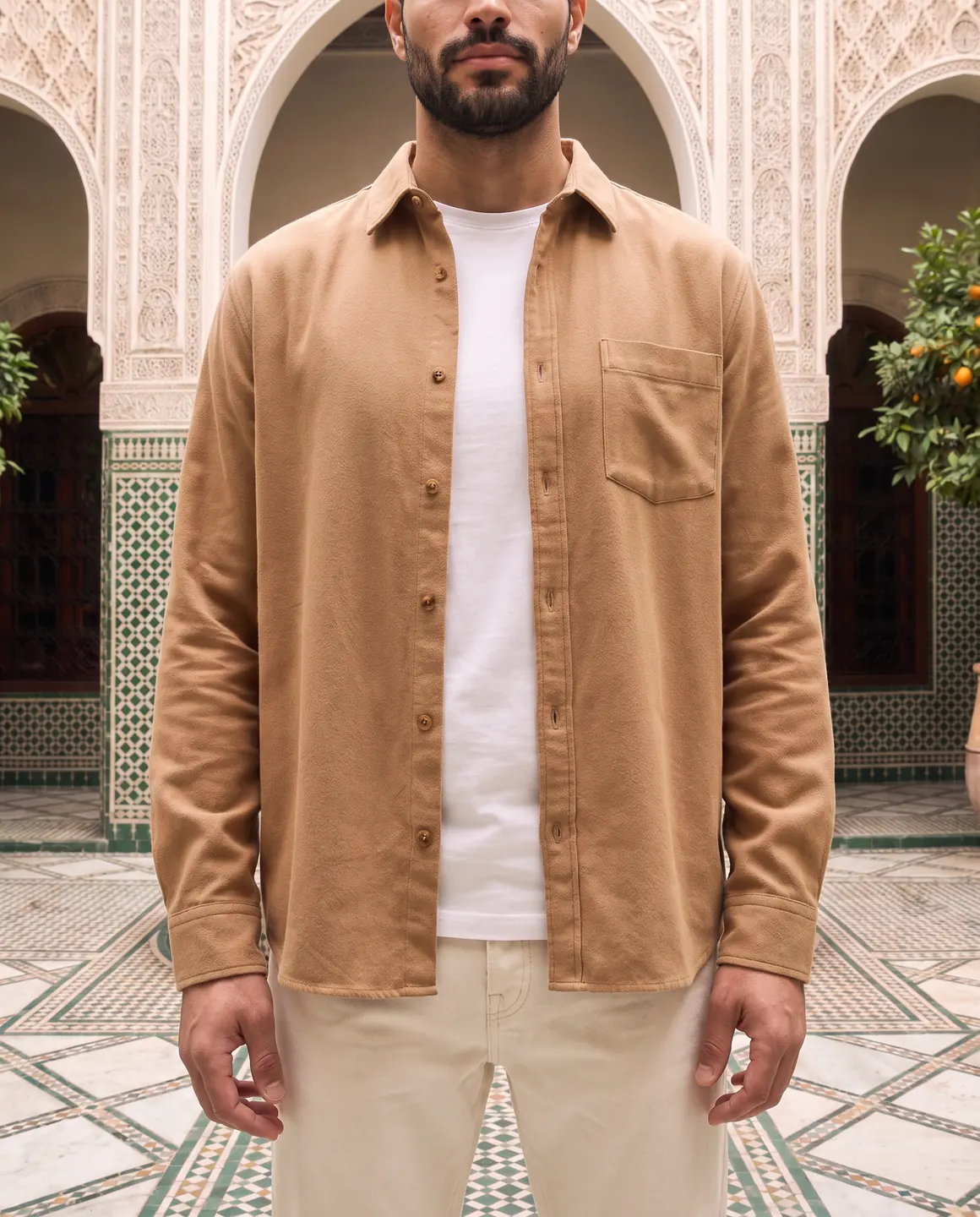 A close crop of the camel overshirt's collar, chest pocket and buttons