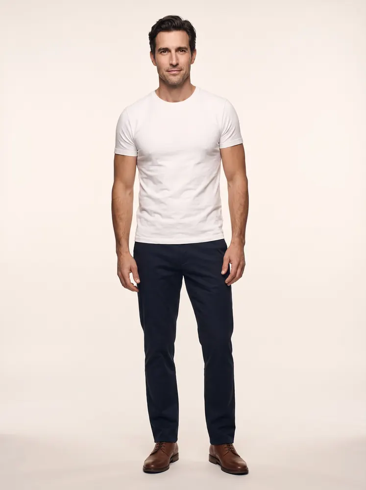 Hugo, a fictional AI model: full length, with dark hair and light stubble, in a white tee and dark trousers