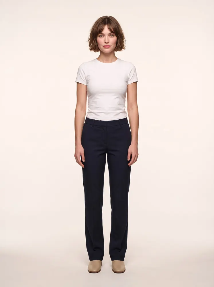 Margaux, a fictional AI model: full length, with a short brown bob, in a white tee and dark trousers