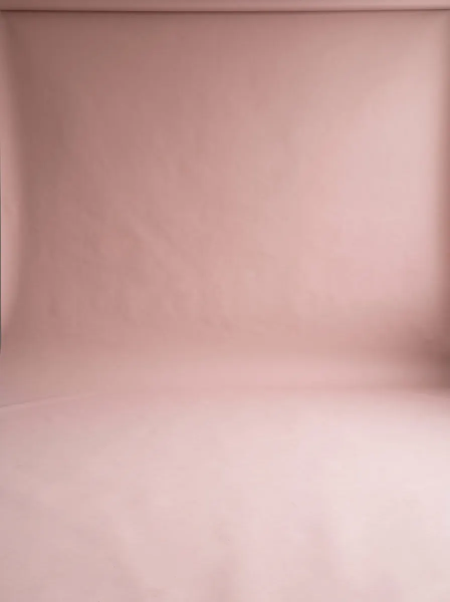 Dusty blush-pink backdrop and floor in soft, even light