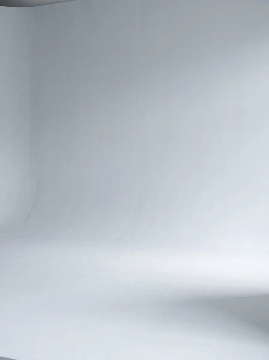 Pale dove-grey backdrop sweeping into the floor under bright, even light